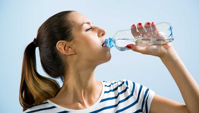 Девушка пьет минеральную воду